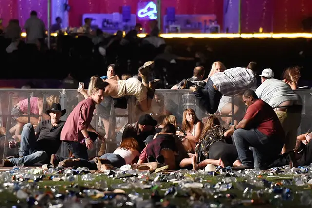 People scramble for shelter at the Route 91 Harvest country music festival after apparent gun fire was heard on October 1, 2017 in Las Vegas, Nevada.